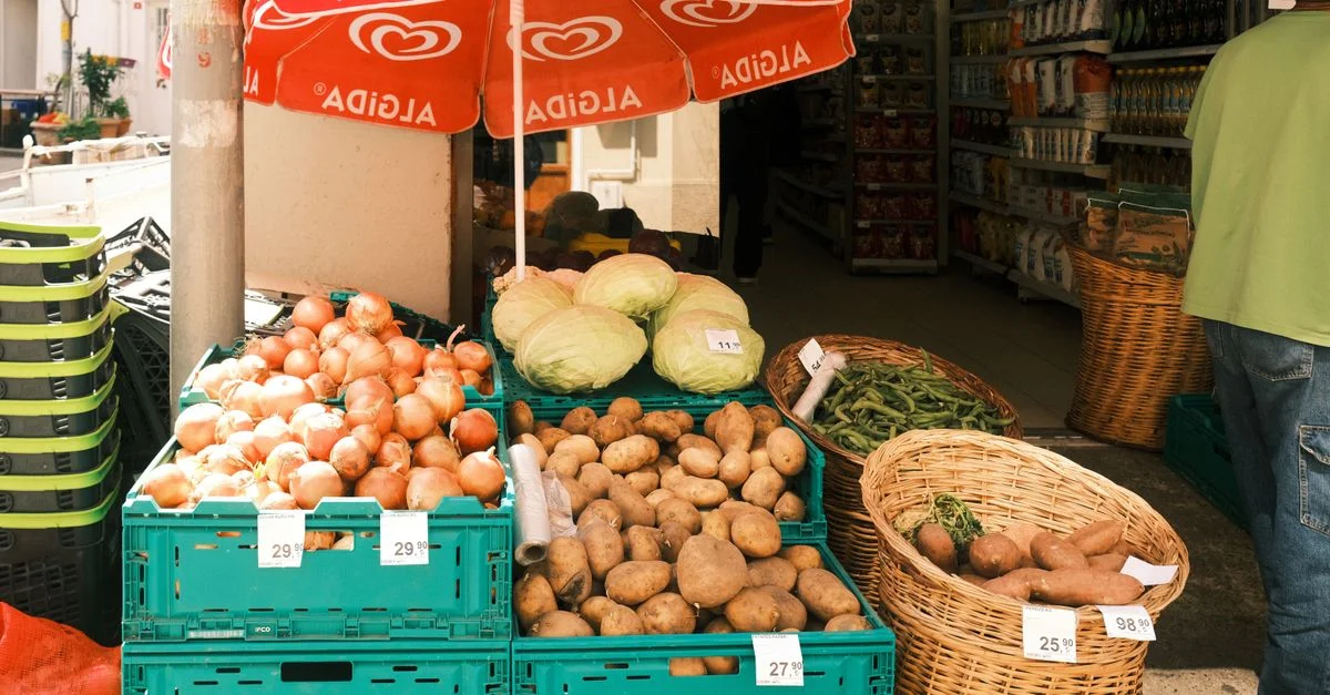 Affichage vivant du marché d'oignons, de choux et de pommes de terre sous un parapluie Algida.